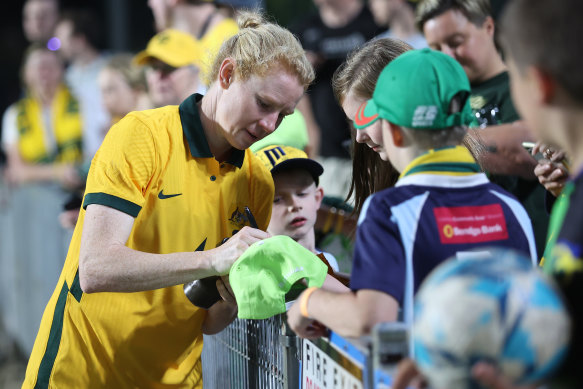 Clare Polkinghorne signs autographs after her record-breaking 152nd game for the Matildas.