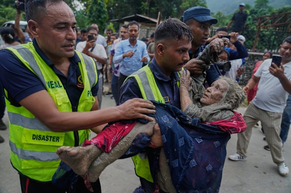 Rescuers carry a victim of flash flooding to safety along the Trishuli River in Nepal’s Nuwakot district.