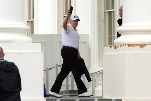 US President Donald Trump waves as he walks into the White House on Sunday.