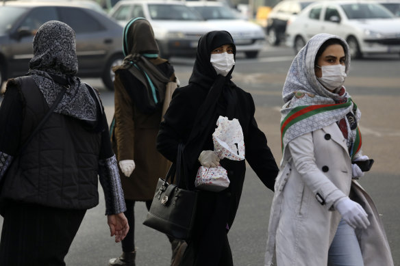 Pedestrians wearing face masks cross a square in western Tehran, Iran, 