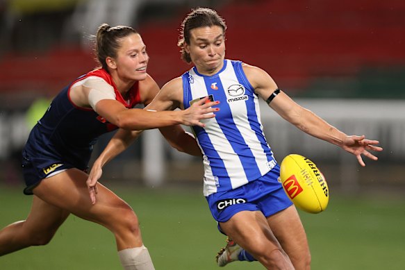 Ash Riddell of the Kangaroos kicks the ball.