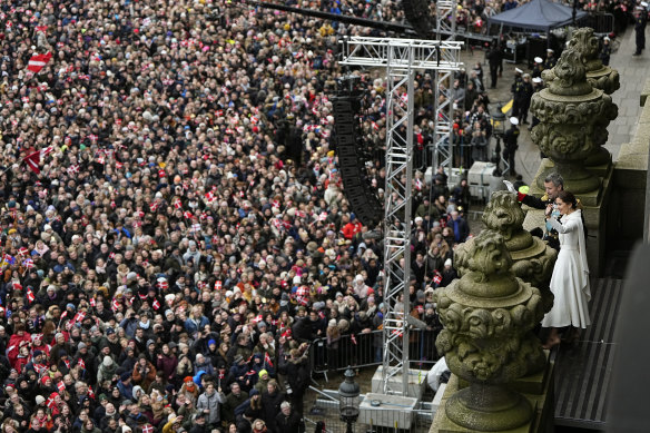 King Frederik X and Queen Mary wave to the crowd from the balcony of Christiansborg Palace.