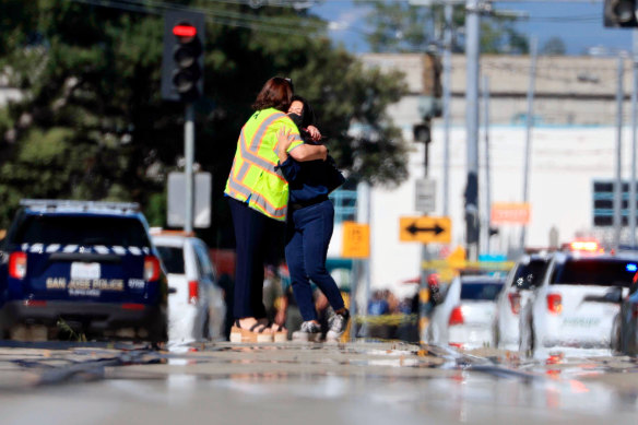 Two people hug in the street near the rail yard where nine people were shot dead in San Jose.