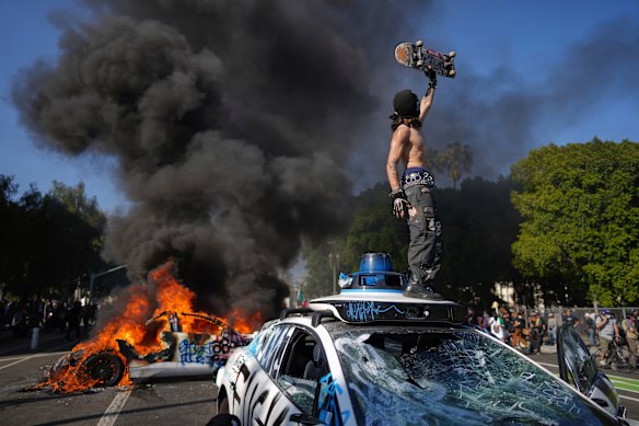 A protester stands on a taxi in LA.