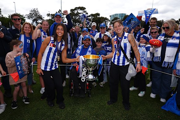 Teammates Taylah Gatt and Tess Craven share the joy of North Melbourne’s premiership win with their fans.