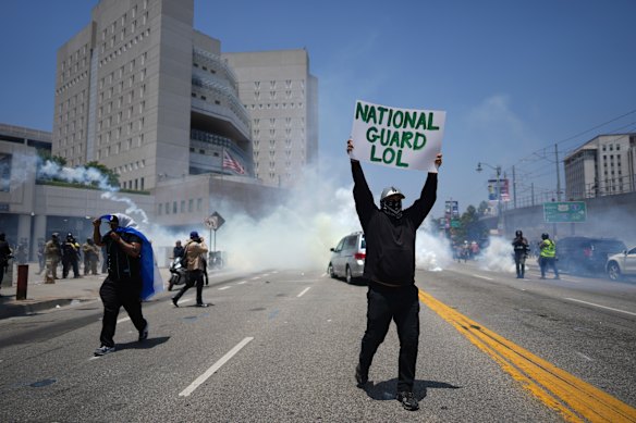 Protesters in the street as tear gas is fired at them on Sunday.