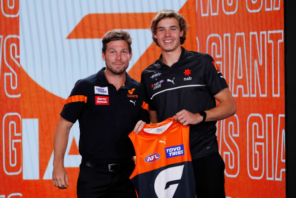 No.1 draft pick Aaron Cadman is presented with his Giants jumper by Toby Greene.