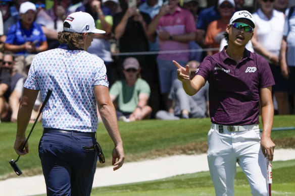 Min Woo Lee jokes with Cam Smith on the seventh hole at The Australian on Friday.
