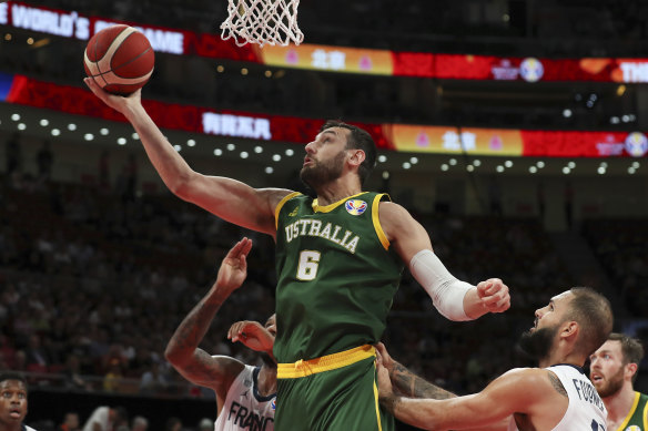 Andrew Bogut of Australia puts up a shot over Amath M’Baye, left, and Evan Fournier of France during their third placing match for the FIBA Basketball World Cup.