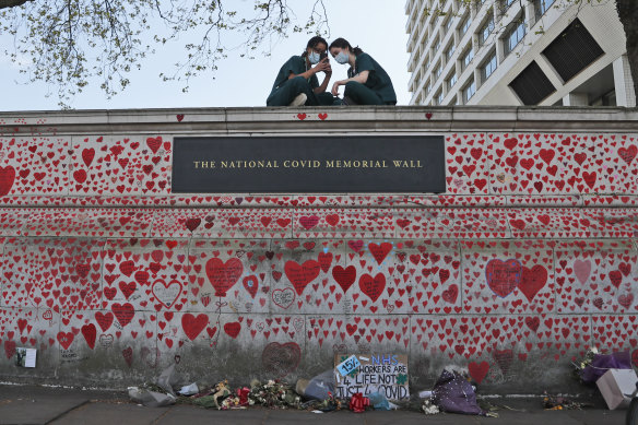 Nurses from the nearby St Thomas’ Hospital take a break atop the National COVID Memorial Wall in London.