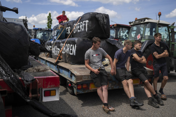 Protesting farmers talk at a blockade outside a distribution centre for supermarket chain Aldi in the town of Drachten, northern Netherlands, on July 4.
