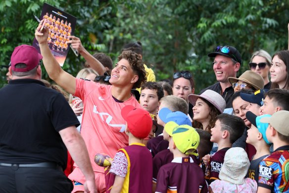 Say cheese: Reece Walsh with the Broncos’ faithful on a murky morning in the Queensland capital.