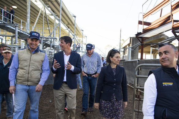 Premier Gladys Berejiklian and Deputy Premier John Barilaro at the Clydesdale live stock market in Singleton, alongside the Nationals candidate for Upper Hunter David Layzell (blue jacket). 