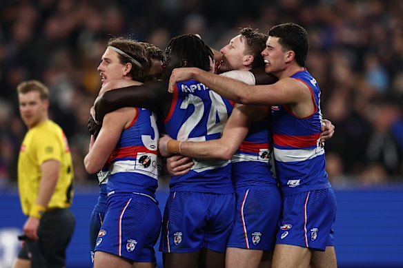 Jubilation: The Bulldogs celebrate their narrow win over Collingwood in the AFL’s inaugural wildcard final.