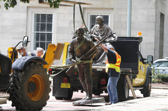 Crews add The Henry Wyatt Monument to a truck after removing them from the North Carolina State Capitol in Raleigh, North Carolina on Saturday, June 20.