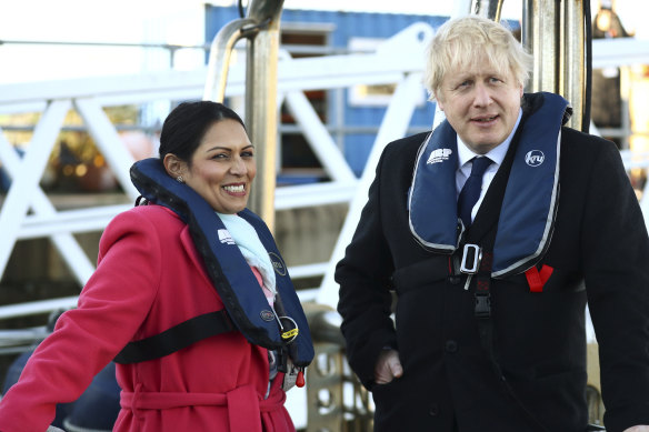 Britain's Home Secretary Priti Patel with Prime Minister Boris Johnson aboard a security boat in the Port of Southampton during election campaigning in 2019.