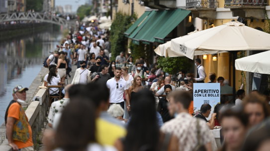 Visitors walk past restaurants in the Navigli suburb of Milan, Italy, last month.