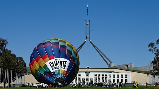 A climate change rally sets up outside Parliament House on Tuesday.