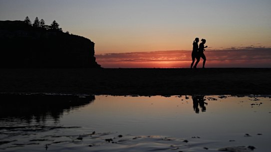 Smoke from hazard-reduction burns adds to the dawn glow over Avalon Beach in Sydney's north as winter makes way for spring.