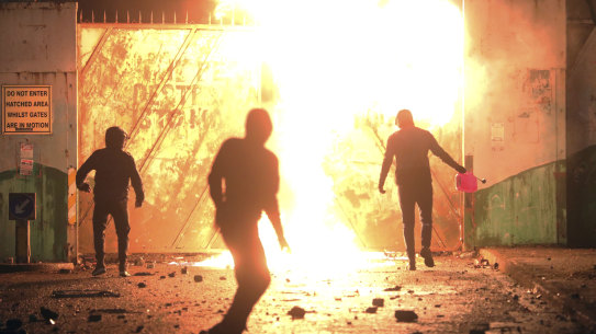 Nationalists and Loyalists clash with one another at the peace wall on Lanark Way in West Belfast, Northern Ireland, on Wednesday.