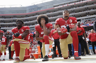 Colin Kaepernick (centre), then the quarterback of the San Francisco 49ers, takes a knee during the national anthem with teammates Eli Harold (left) and Eric Reid at an NFL game in October 2016.