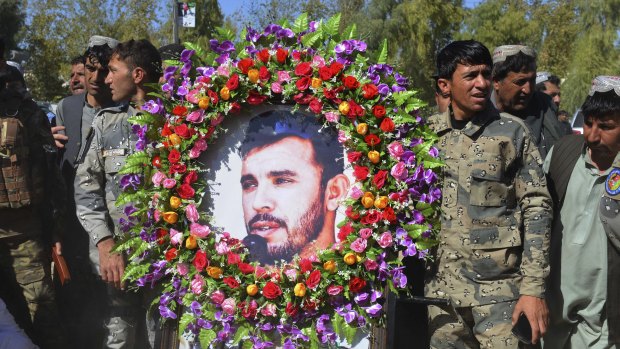 Military personnel held a photo of General Abdul Raziq, Kandahar police chief, who was killed by a guard, during his burial ceremony in Kandahar, Afghanistan, on Friday.
