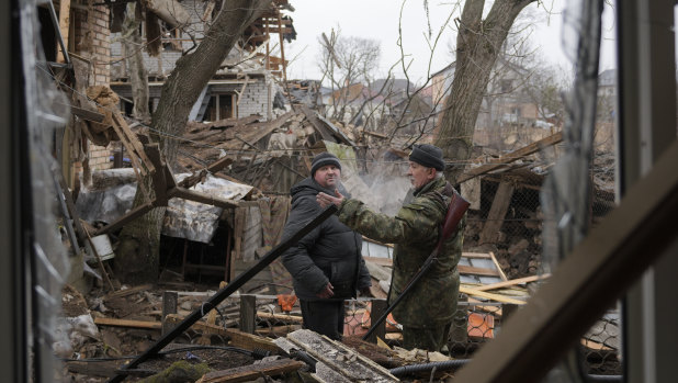 Andrey Gonchruk, 68, right, a member of the territorial defence, speaks to a man in the backyard of a house damaged by a Russian airstrike, according to locals, in Gorenka, outside the capital Kyiv, Ukraine.