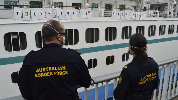 Australian Border Force officers watch the Artania as it departs Fremantle. 