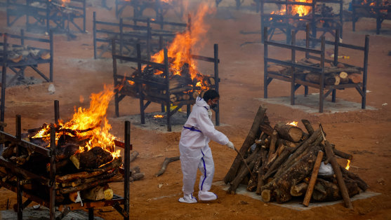 A man performs the last rites for a COVID-19 victim at an old granite quarry repurposed into a crematorium in Bengaluru, India.