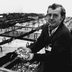 Reg Ree, leading hand at The Royal Australian Mint, Canberra,  displays dollar coins from one of the numerous containers of finished coins in the cashier vault. May 25, 1984. 