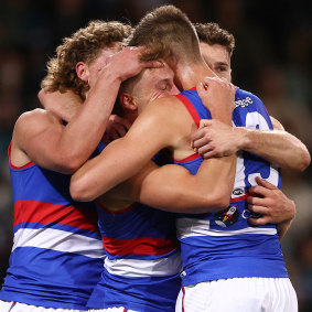 Roarke Smith’s teammates get around him after a goal against Port Adelaide in the preliminary final.