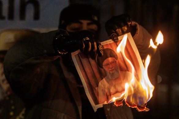1月14日、ロンドンのイラン大使館前での抗議活動中に、デモ参加者がイラン最高指導者アリ・ハメネイ師の肖像画を燃やす。