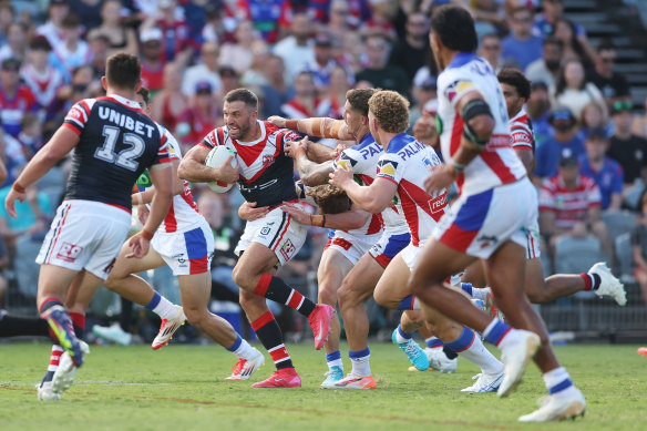 Roosters fullback James Tedesco is tackled by a gang of Knights.