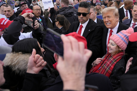 Donald Trump takes a photo with a supporter at a campaign stop in Londonderry, New Hampshire.