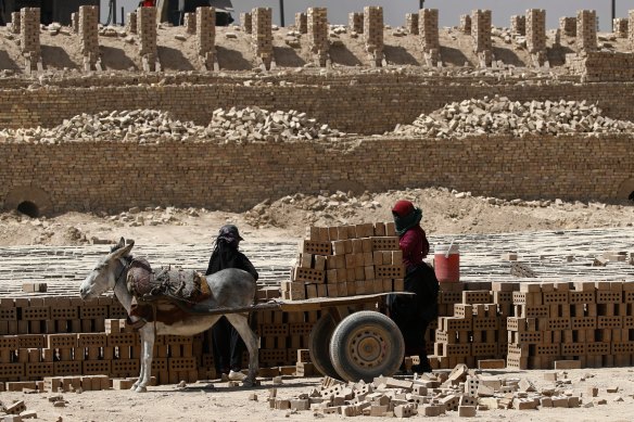 Women work at a brick factory in Baghdad’s south-east suburb of Nahrawan, Iraq. They work 12 hours a day for about $US15 ($20). Iraq has been invited to Joe Biden’s summit of democracy.