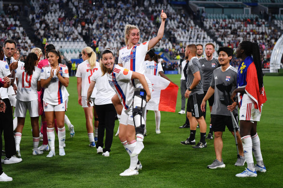 Ellie Carpenter is helped through the post-match celebrations by teammate Damaris Egurrola after the Australian defender ruptured her ACL in the Champions League final against Barcelona in 2022.