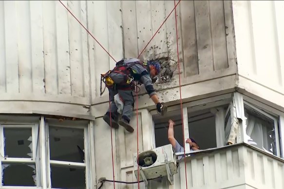 Müfettişler, Moskova'da bir Ukrayna insansız hava aracı tarafından hasar gören bir apartman binasını inceliyorlar.