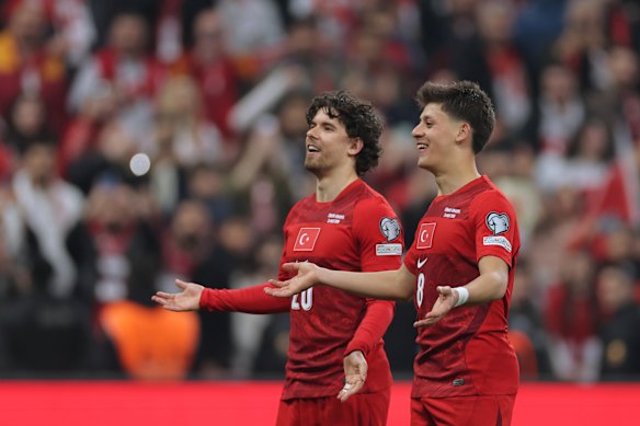 Turkey’s Ferdi Kadioglu and Arda Guler celebrate their World Cup play-off victory.