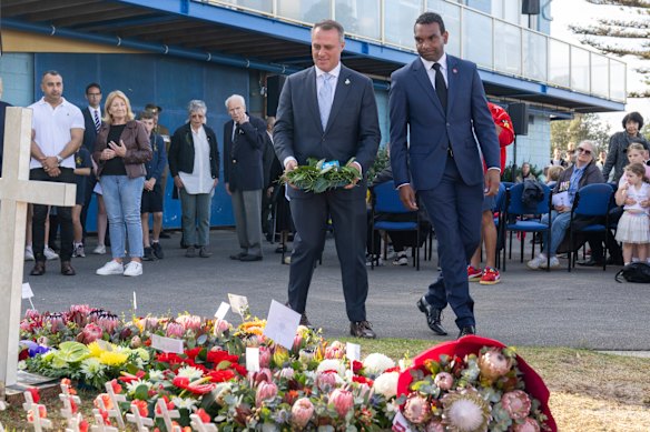 Wilson and the Liberal candidate for Macnamara Benson Saulo lay a wreath together at the sailing club event.
