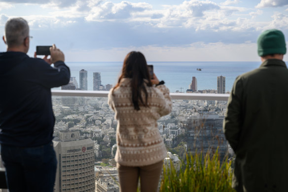 People watch the helicopter carrying released hostage Ohad Ben Ami as it arrives at Ichilov Hospital in Tel Aviv.