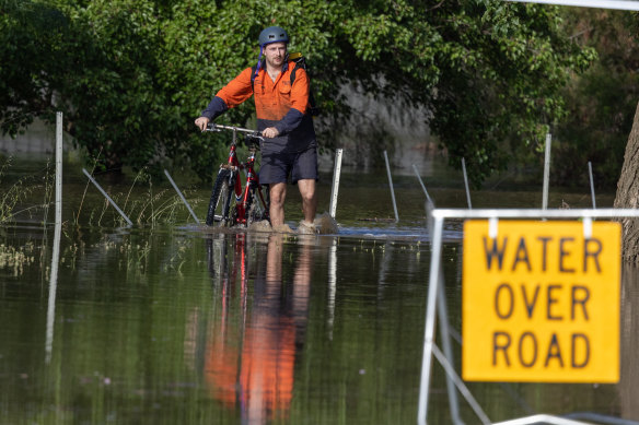 A man pushes his bike through floodwaters in Rochester.