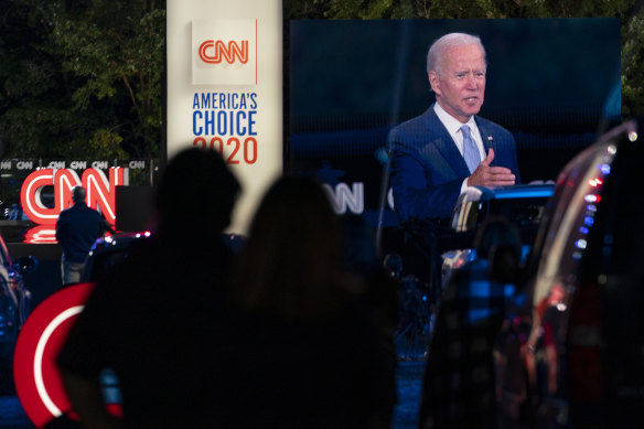 Audience members watch from their cars as Democratic presidential candidate former vice-president Joe Biden, seen on a monitor, speaks during a CNN town hall in Moosic, Pennsylvania.