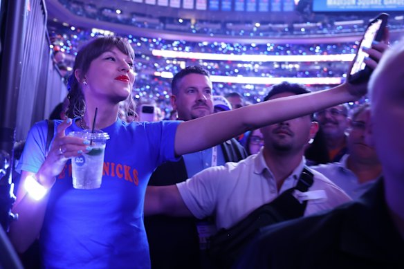 Taylor Swift takes a selfie at half-time with a fan, as the celebrities kept flocking to Knicks games.