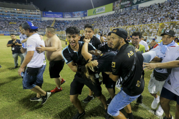 An injured fan in carried to the field of Cuscatlan stadium in San Salvador, El Salvador, Saturday.