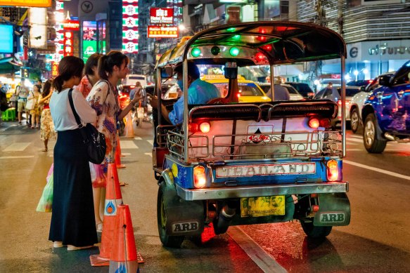 Tourists haggle over the price of a tuk tuk in Bangkok.