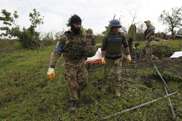 Ukrainian soldiers carry a body of their comrade-in-arms killed in a battle against the Russian troops in the Kharkiv region, Ukraine.