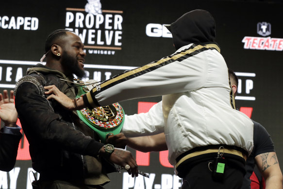 Deontay Wilder and Tyson Fury shove each other during their press conference.