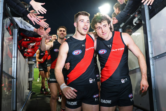 Victorious Bombers skipper Zach Merrett walks off the MCG arm-in-arm with deputy Andy McGrath.