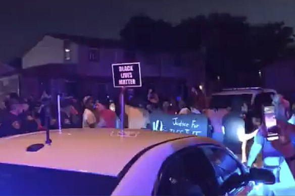 Protesters gather near the site of the police shooting on Sunday night. 