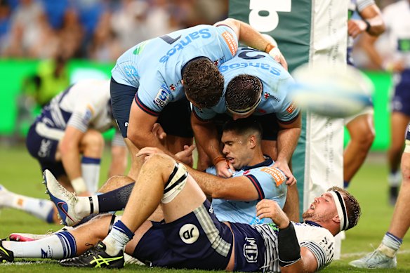 The Waratahs celebrate after Jack Debreczeni’s try. 